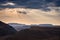 Dramatic sky, storm clouds and sun rays glowing over valleys, canyons and table mountains of the majestic Golden Gate Highlands Na