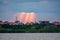 Dramatic sky with sunbeams through the clouds over lake with houses on the shore