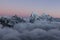 Dramatic snowy Cholatse ridge rising above field.