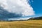 Dramatic storm cloud and rain over a vast landscape and grasslands