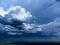 Dramatic storm clouds cast shadows over rural landscape