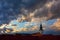 Dramatic stormy and cloudy sky at sunset over roof and church tower in historic city Uherske Hradiste