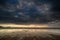 Dramatic stormy sky landscape reflected in low tide water on Rho