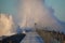 Dramatic, strong waves and foam spray hit the pier in Vorupoer on the North Sea coast of Denmark