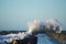Dramatic, strong waves and foam spray hit the pier in Vorupoer on the North Sea coast of Denmark