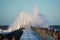 Dramatic, strong waves and foam spray hit the pier in Vorupoer on the North Sea coast of Denmark