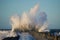 Dramatic, strong waves and foam spray hit the pier in Vorupoer on the North Sea coast of Denmark