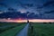 Dramatic summer sunrise over Dutch farmland with windmill