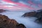 Dramatic sunrise landscape with flowing fog and pink skies in the Dolomites