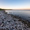 dramatic sunrise over the baltic sea with rocky beach and trees