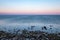 dramatic sunrise over the baltic sea with rocky beach and trees