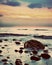 Dramatic sunrise on a rocky beach. Retro, vintage