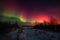 dramatic sunrise, with solar flare visible in the sky and geomagnetic storm causing colorful aurora