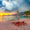 Dramatic sunset at beach with chaise lounges and umbrellas in Sveti Stefan near Budva