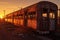 dramatic sunset casting shadows on abandoned train carriages