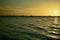 Dramatic sunset colours; beautiful sunset on a beach. Sun reflection in the water, with yacht silhouettes far away