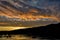 Dramatic sunset landscape with lake, sky reflection, fishing boat and foothills silhouette Snake River on the border of Idaho and