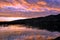 Dramatic sunset landscape with lake, sky reflection, fishing boat and foothills Snake River on the border of Idaho and Washington