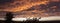Dramatic sunset like fire in the sky with golden clouds. panoramic picture