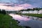 Dramatic sunset sky over the Tvertsa River and its picturesque shores after storm. Russian provincial town Torzhok, Tver region.