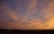 Dramatic sunset or sunrise in orange and purple over open field