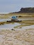 Dramatic Texture of Beach during Low Tide resembling random vein pattern with wooden boats and house in the background