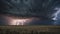 A dramatic thunderstorm over a vast, open prairie with lightning streaking across the