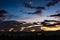 Dramatic twilight sky with moon above the light of small town.