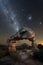 A dramatic vertical night sky landscape photograph of an incredible rock arch