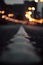 Dramatic vertical shot of an asphalt road with light bokeh