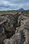 Dramatic view of deep volcanic crustal crack, hiking trail and h