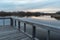 Dramatic view of still lake water from a wooden dock on a misty Autumn evening