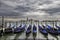 Dramatic view of Venice with row of gondolas docked to the poles