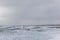 A dramatic view of a very choppy sea with huge crashing waves on groynes breakwater during a major storm under a grey sky