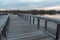 Dramatic view from a wooden lake dock overlooking the stillness on a lake and forest at sunset in Autumn