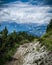 Dramatic vintage view of narrow and difficult rocky trekking trail across mountain peak in cloudy summer day