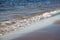 Dramatic wave crashing on the shoreline, with wind blown spray. Water splashing background. Wave crashing on the beach