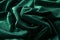 Draped velvet fabric in trendy green color. Abstract modern background