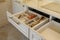 Drawer pulled out in cabinet at luxury beige and gold classic kitchen furniture
