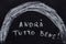 Drawing with chalk on a black blackboard with text Andra tutto bene