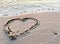 Drawing hearts on the sandy shore. Sign drawn on the sand, closeup. Concept: Declaration of Love