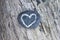 Drawn heart on stone lying on wood