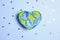Drawn planet Earth in the shape of a heart among the stars on a blue background. Earth Day, 22 april