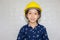 Dream career concept, Portrait of Happy engineer kid in hard hat looking at camera on blurred background
