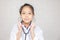 Dream careers concept, Portrait of Happy kid in doctor coat with stethoscope blurred background