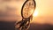 Dream catcher with white feathers flying in wind sun. Hunter of dreams against sunset