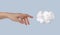 Dream concept. Hand touching cotton cloud at blue sky background. Freedom of mind