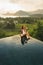 Dream journey Asia. Woman on edge luxury infinity pool an enjoying amazing view