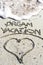 Dream vacation phrase handwritten on the sandy beach