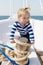 Dreamer kid in striped marine shirt. small sailor on boat. let dream come true. summer vacation. child dream to be